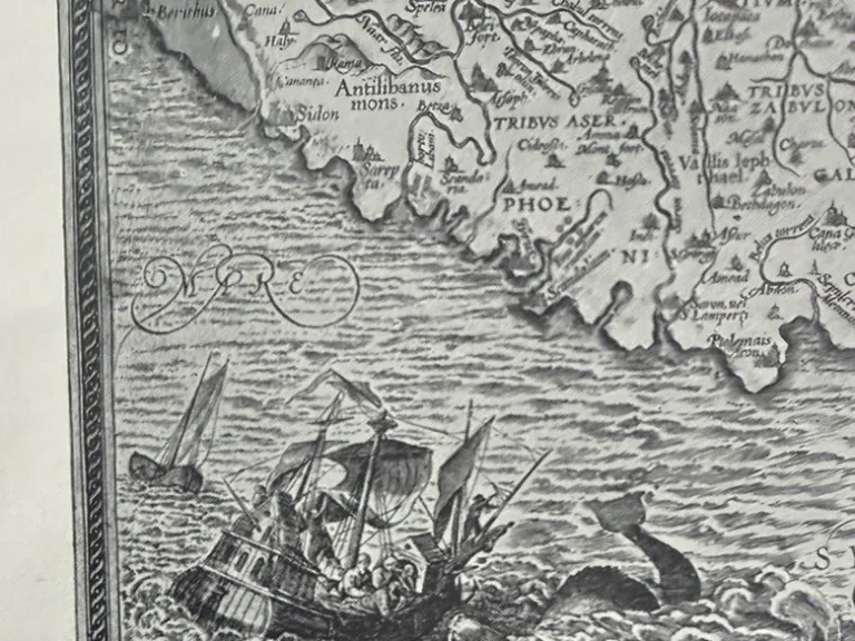 Detail of a Terra Sancta map reproduction showing a sailing ship, curled sea creature and lower paper edge