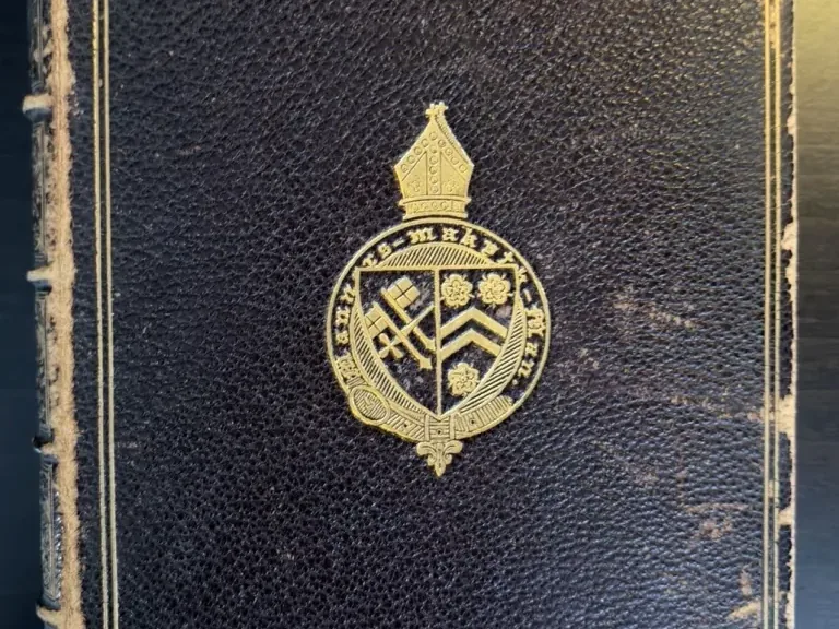 Dark leather binding with gilt borders and Winchester College device