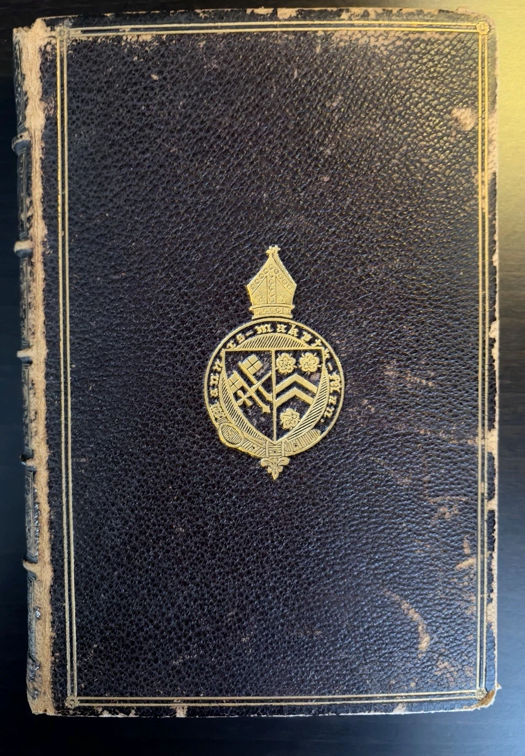 Dark leather binding with gilt borders and Winchester College device