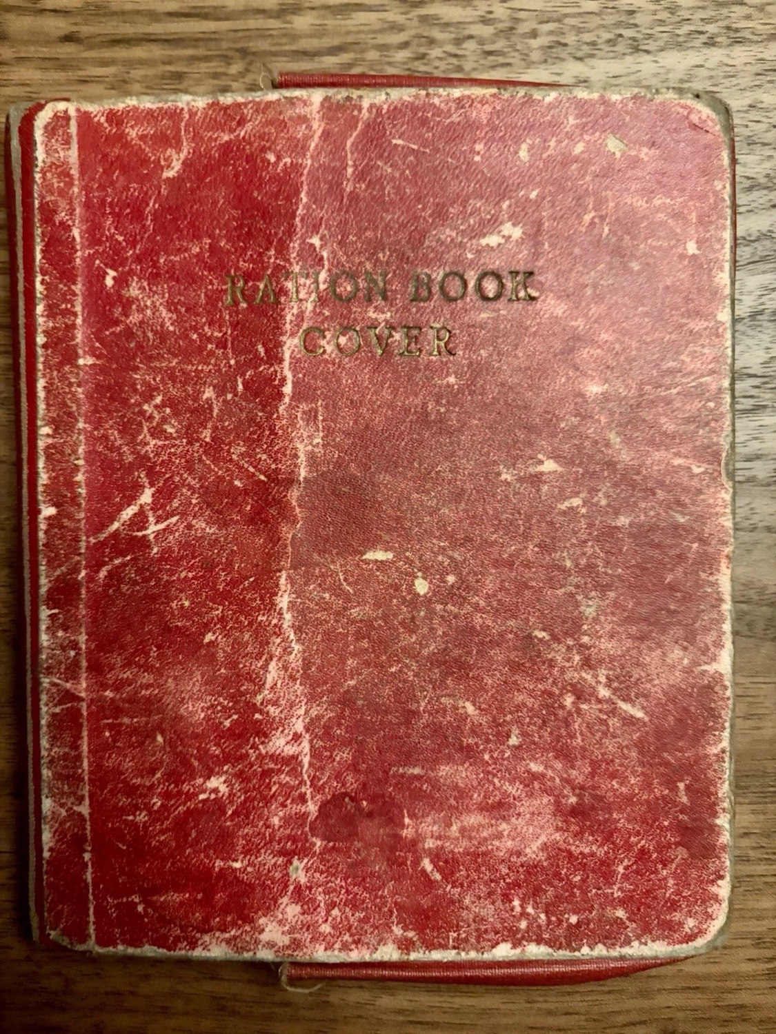A worn red British ration book cover