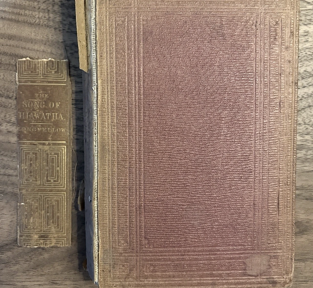 The worn cloth-covered front board of this copy beside its detached gilt-lettered backstrip